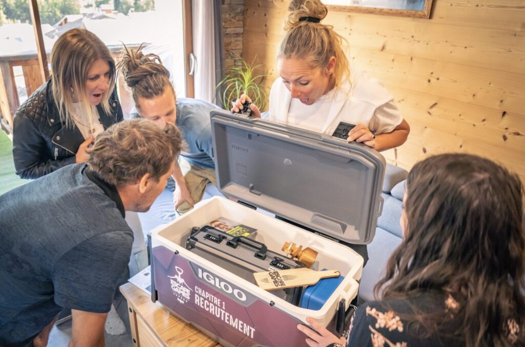 Groupe de personnes (hommes et femmes) autour d'une glacière EGA chapitre 1 qui découvrent le contenu