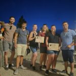 groupe de personne à l'extérieur qui sourient avec un diplôme d'enquêteur